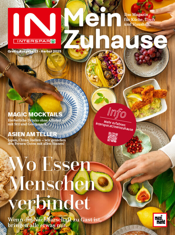 Ein buntes Cover eines Magazins mit dem Titel "Mein Zuhause". Es zeigt verschiedene Lebensmittel und Getränke wie Cocktails, Obst und Gemüse. Im Vordergrund hält eine Hand ein Glas mit einem bunten Getränk.